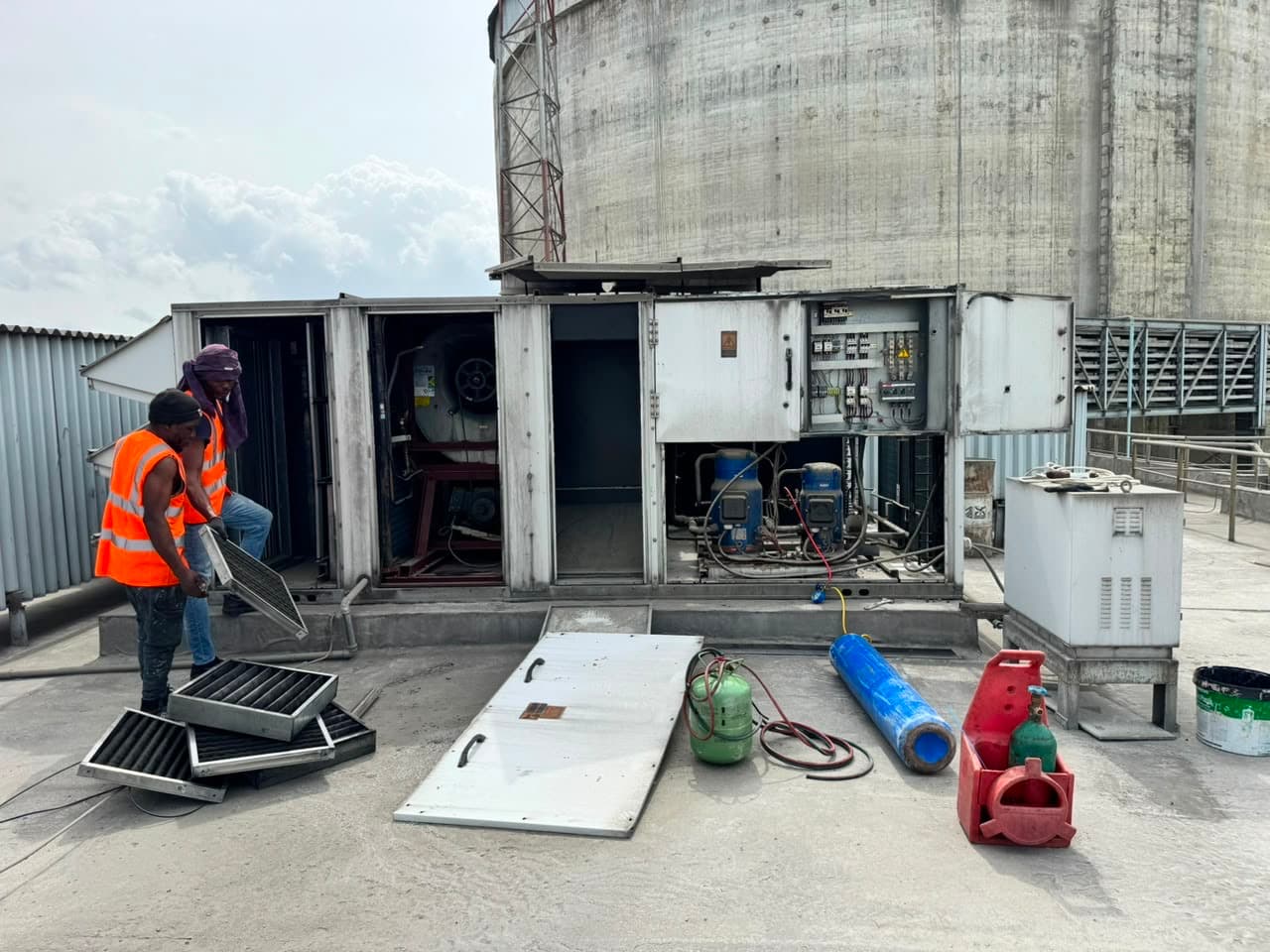 Helmont field team servicing rooftop HVAC equipment on an active industrial site